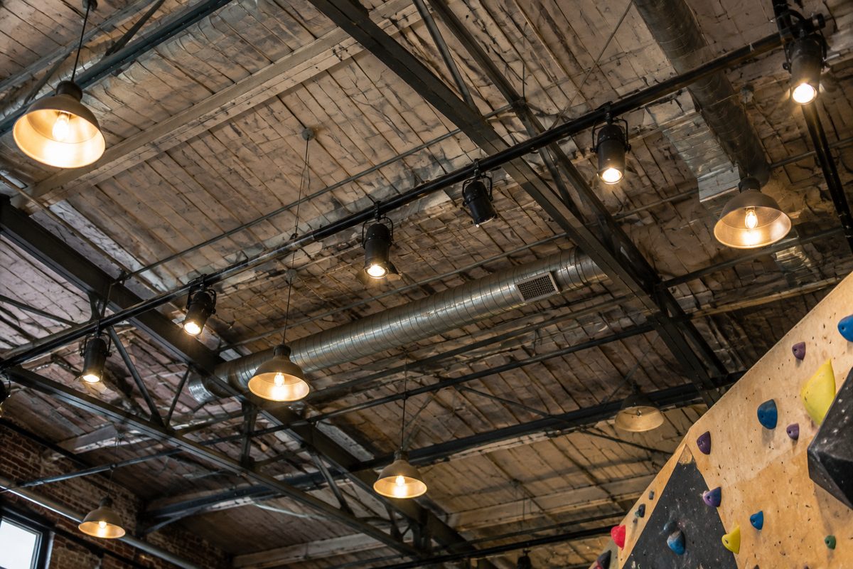 Steel trusses and hanging lamps across the gym ceiling